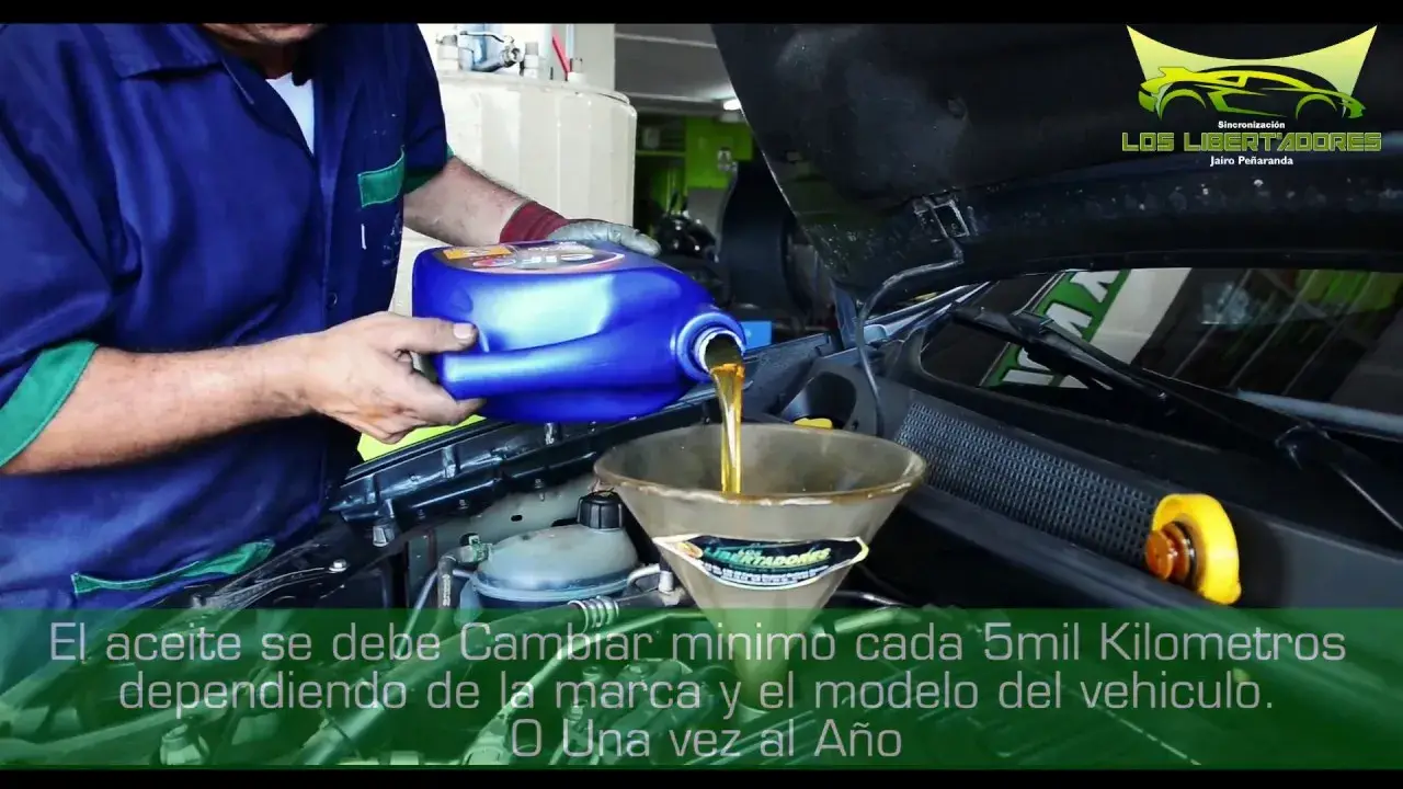 Mecánico echando aceite nuevo al motor de un carro